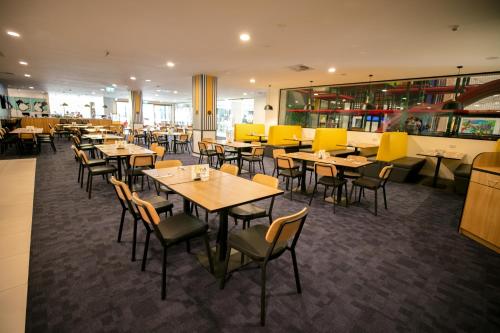 a dining room with tables and chairs in a restaurant at Paradise Resort Gold Coast in Gold Coast
