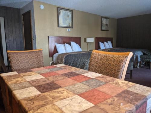 a hotel room with two beds and a table with chairs at Cabana Inn - Boise in Boise