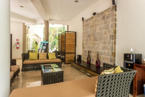 a living room with a couch and a table at Hacienda Paradise Hotel in Playa del Carmen