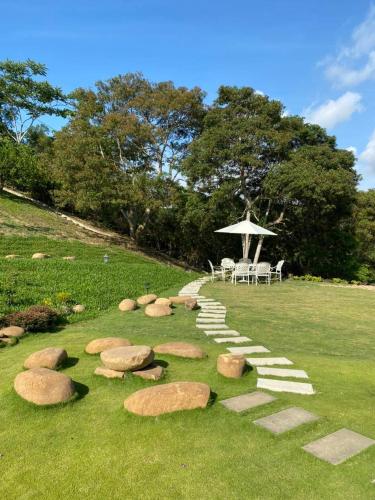 a path with rocks and a table and chairs on a field at 印象莊園包棟民宿,一日一組客人,依人數開房 in Xihu