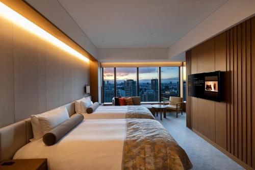 a hotel room with two beds and a large window at The Okura Tokyo in Tokyo