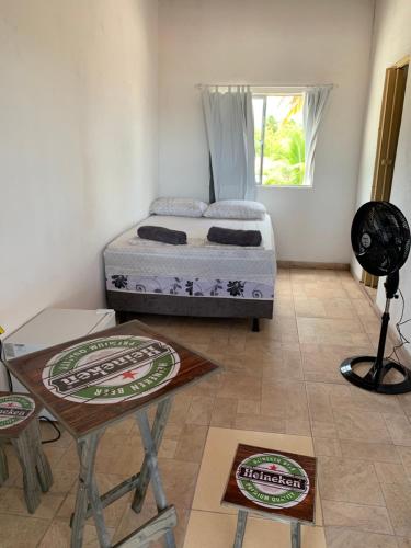 1 dormitorio con 1 cama y 1 mesa en una habitación en Pousadinha da Lulu - Pontal Mangue Seco, en Indiaroba