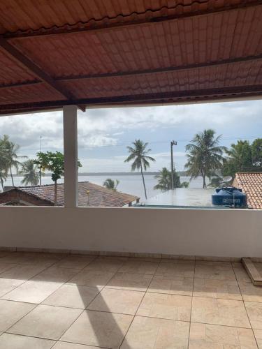 an empty room with a view of the ocean and palm trees at Pousadinha da Lulu - Pontal Mangue Seco in Indiaroba