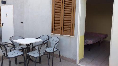 a room with a table and chairs and a bed at Quadruple room in Pineto - Just a few meters from the sea in Pineto