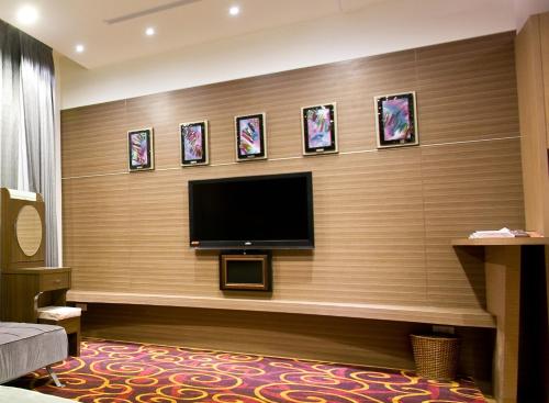 a flat screen tv on a wall with pictures at Zhi Da Craft Service Guest House in Caotun