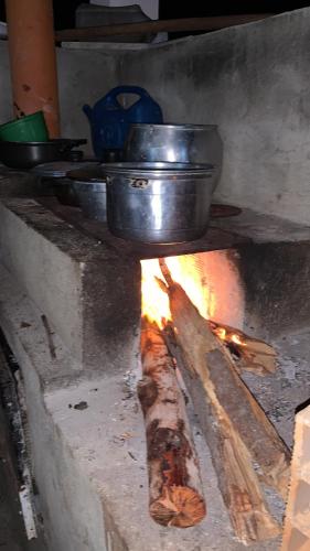 a piece of meat cooking over a fire in an oven at Pousadinha da Lulu - Pontal Mangue Seco in Indiaroba