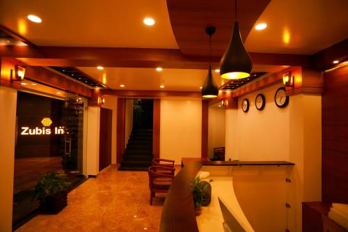a room with a lobby with a bar and a hallway at Zubis Inn Hotel in Kalpetta