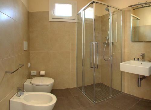 a bathroom with a shower and a toilet and a sink at Hotel Helvetia in Lido di Jesolo