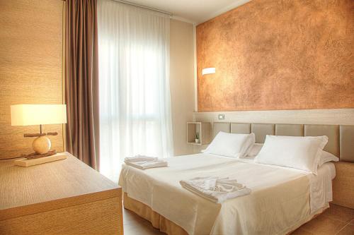 a hotel room with a bed and a window at Hotel Helvetia in Lido di Jesolo