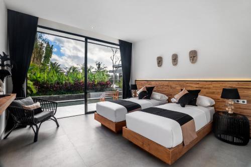 um quarto com 2 camas e uma grande janela em Ubud Luxury Resort em Ubud