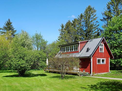 un granero rojo en medio de un campo en 4 person holiday home in HEMSE, en Hemse