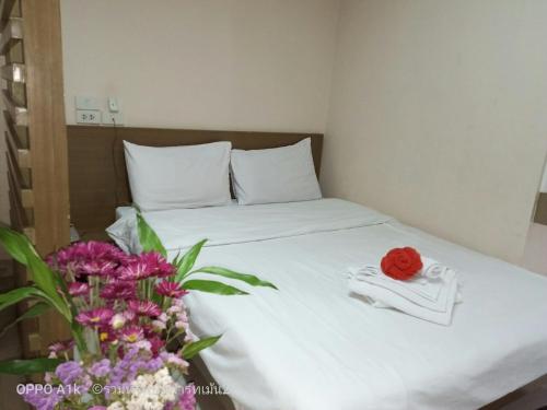 a bed with a towel and flowers on it at ruamsab2 รวมทรัพย์2 in Ban Na Song