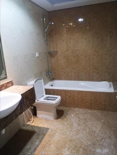 a bathroom with a toilet and a sink and a tub at Amazing Homestay Partition Room for 1 in Dubai