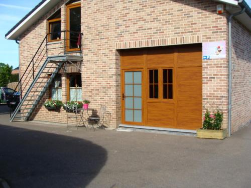 a brick building with a garage with a wooden door at Echappée Belle in Jalhay