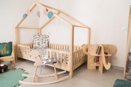 una camera per bambini con culla in legno e area giochi. di Family Green Suite a Marsala