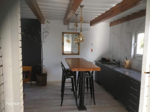 a kitchen with a wooden table and chairs at Holiday Home Wanderlust Lendava in Lendava