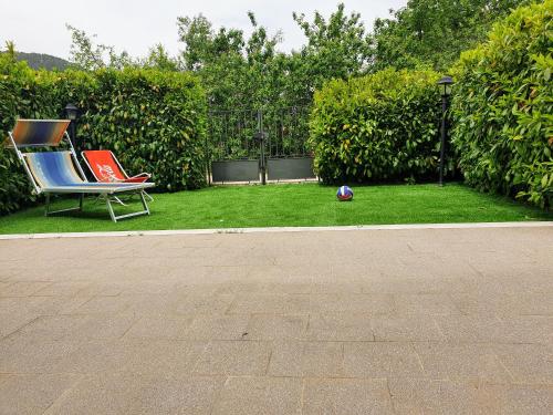 une paire de chaises et une boule sur l'herbe dans l'établissement Relax Pescasseroli For Ever, à Pescasseroli