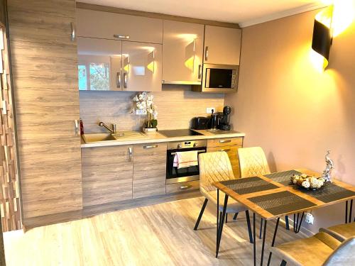 a kitchen with a table and a sink and a stove at Silver Gellért Apartman in Siófok