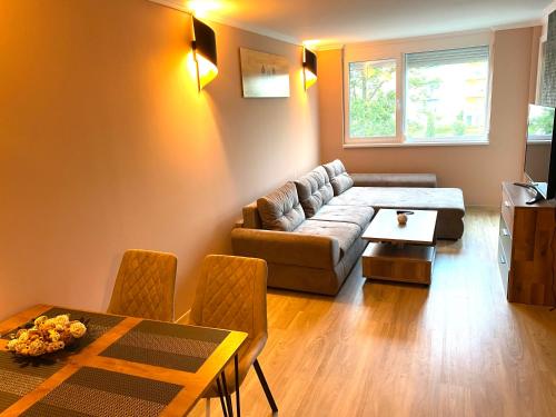 a living room with a couch and a table at Silver Gellért Apartman in Siófok