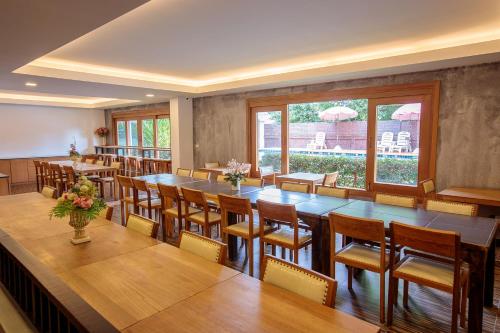 a restaurant with tables and chairs and a large room at Huen Jao Ban Hotel in Chiang Mai