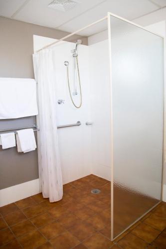 a shower with a glass door in a bathroom at Crystal Fountain Motel Albury in Albury