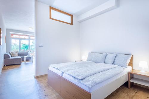 1 dormitorio blanco con 1 cama y sala de estar en Lipno View - Blue Apartment 6, en Lipno nad Vltavou