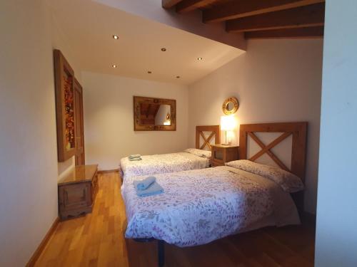 a bedroom with two beds and a blue pair of shoes at Dúplex Mirador de Potes - 4 pax, con Wifi y Garaje in Camaleño