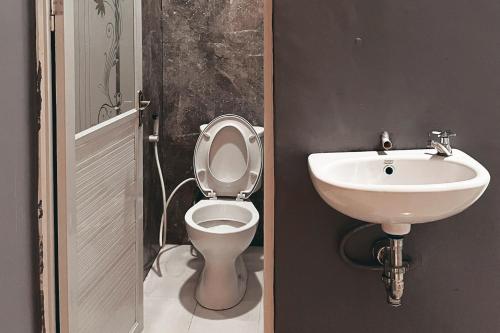 a bathroom with a toilet and a sink at Almira Homestay Ambon Mitra RedDoorz in Ambon
