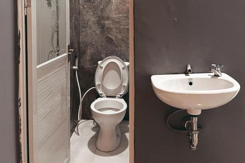La salle de bains est pourvue de toilettes et d'un lavabo. dans l'établissement Almira Homestay Ambon Mitra RedDoorz, à Ambon