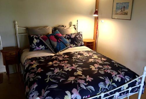 a bedroom with a bed with a floral bedspread at French Island Cottage in Fairhaven