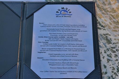 a sign for a bar menu on a wall at Pumula Beach Hotel in Umzumbe