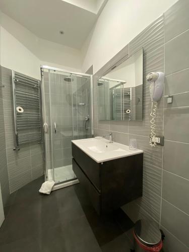 a bathroom with a sink and a shower and a mirror at Amuri Room&Suite in Palermo