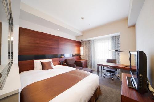 a hotel room with a bed and a desk at Hotel Metropolitan Akita in Akita