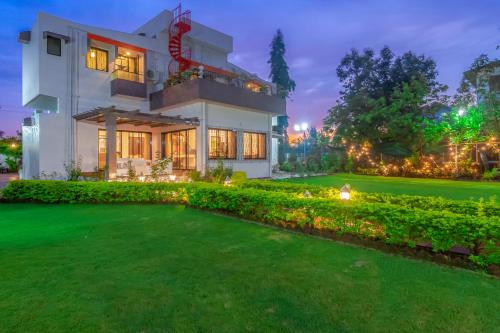 a house with a lawn in front of it at StayVista's Fairfield Villa - A green lawn and charming orchard await your retreat in Lonavala