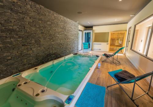 Cette chambre dispose d'un bain à remous et d'un mur en briques. dans l'établissement Villa nestled in greenery, spa and pool - by feelluxuryholidays, au Plan-de-la-Tour