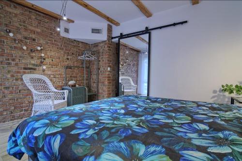 a bedroom with a bed with a colorful blanket at Pokoje i apartamenty przy Sosnowej in Poddąbie