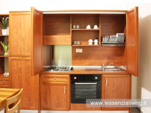 a kitchen with wooden cabinets and a sink at L'ESSENZIAL LIVING in Messina