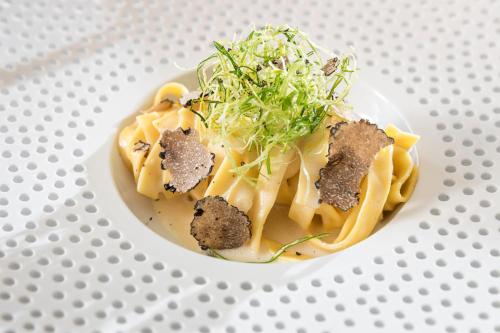 a plate of food with pasta and meat on it at NIDUM - Casual Luxury Hotel in Seefeld in Tirol
