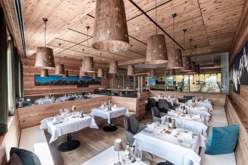 a dining room with white tables and chairs at NIDUM - Casual Luxury Hotel in Seefeld in Tirol