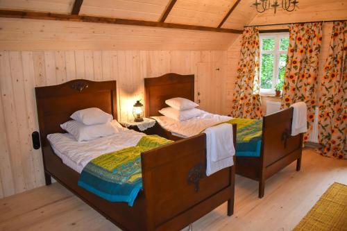 two beds in a room with wooden walls at Bratkowa Chata in Binczarowa