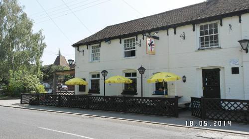 a white building with yellow umbrellas in front of it at The Hawkenbury in Staplehurst