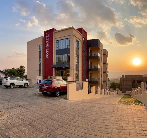 a building with a car parked in a parking lot at Rose Garden Private Apartment By LINK in Kigali