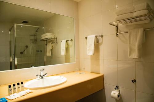 a bathroom with a sink and a mirror at BON Hotel Bloemfontein Central in Bloemfontein
