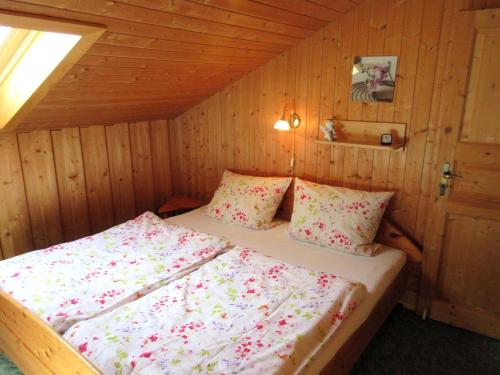 ein Schlafzimmer mit einem Bett in einer Holzhütte in der Unterkunft Ferienwohnung Spitzer in Waging am See