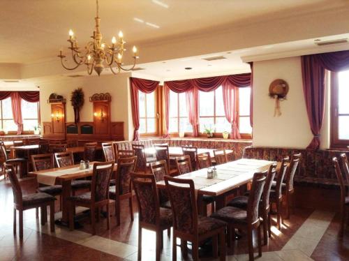 シュピタル・アム・ピュールンにあるLandhotel Oberwengerhofの木製のテーブルと椅子、シャンデリアのあるレストラン