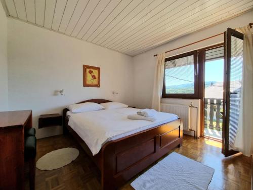 a bedroom with a large bed and a large window at House Hodak in Grabovac