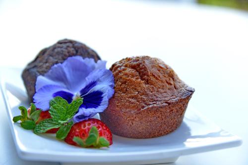 a muffin on a plate with strawberries and flowers at Pumula Beach Hotel in Umzumbe