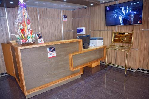 an office with a desk with a tv on the wall at NOUBOU INTERNATIONAL HOTEL BONAPRISO in Douala