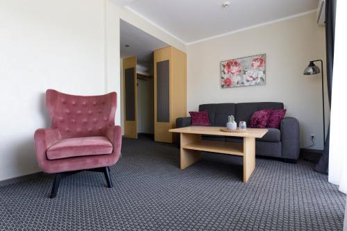 a living room with a couch and a chair and a table at Spa Hotel Ezeri in Sigulda