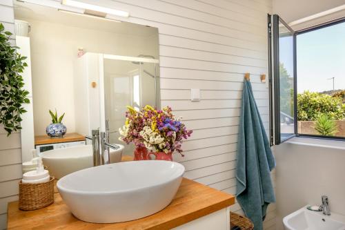 a bathroom with a large white tub and a sink at Like-home-T2 house, pool, AC, garden in Ericeira